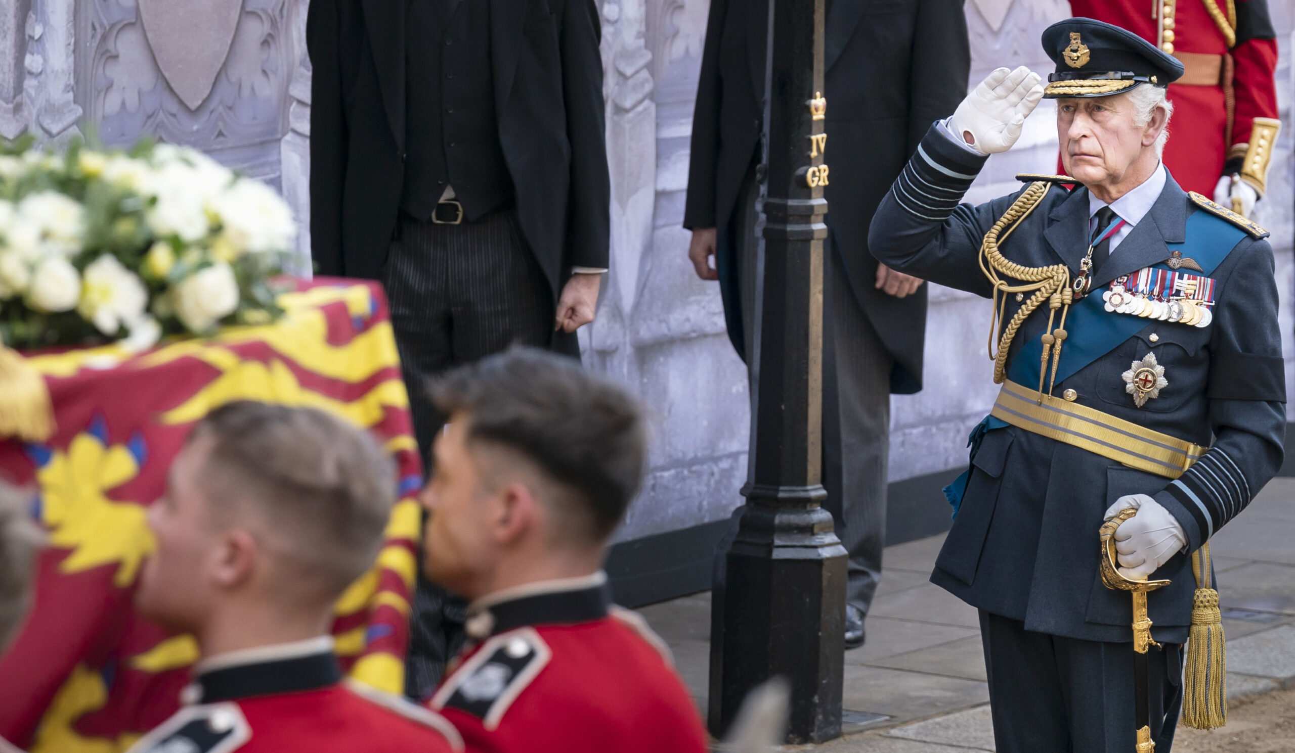Photograph King Charles III saluting the coffin carrying Queen Elizabeth II